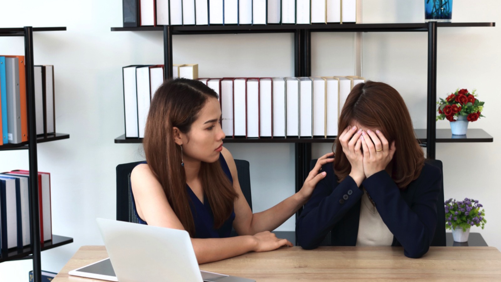 Woman comforting her friend in office
