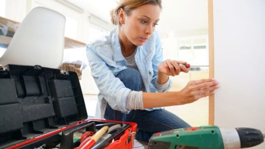 Woman doing DIY at home with toolbox