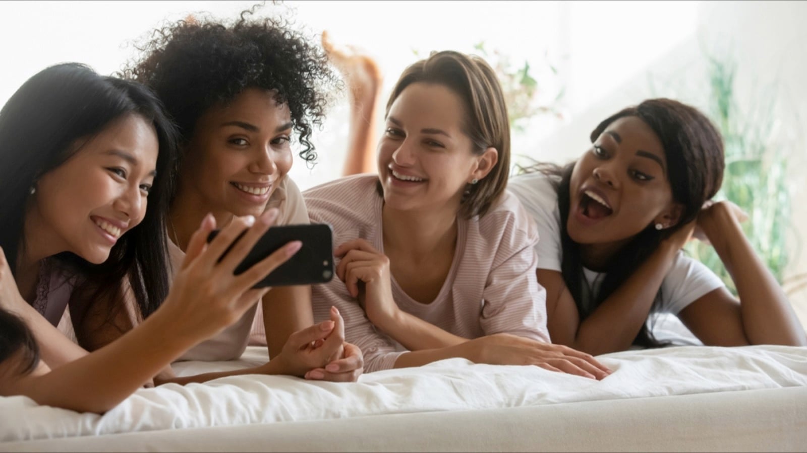 Friends using mobile laughing