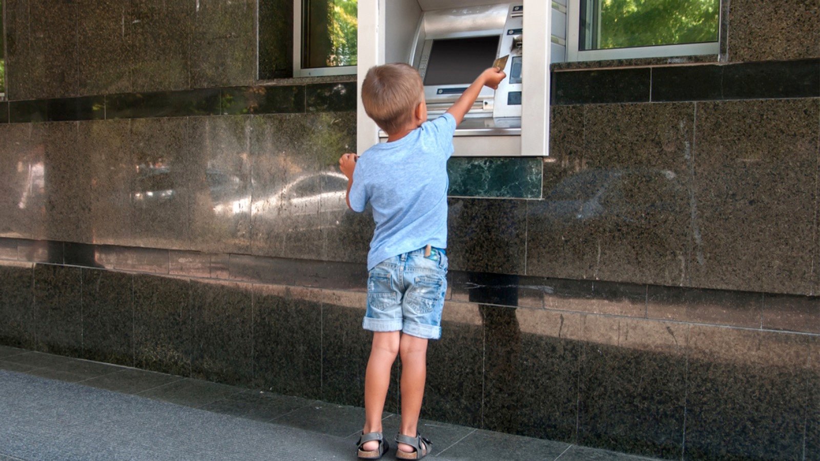 Kid taking cash out of atm