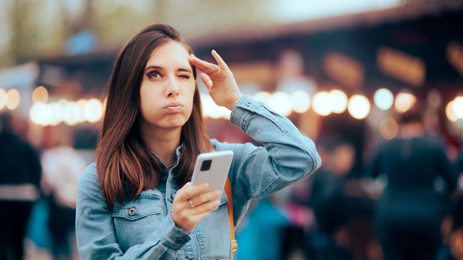 woman holding a phone, thinking