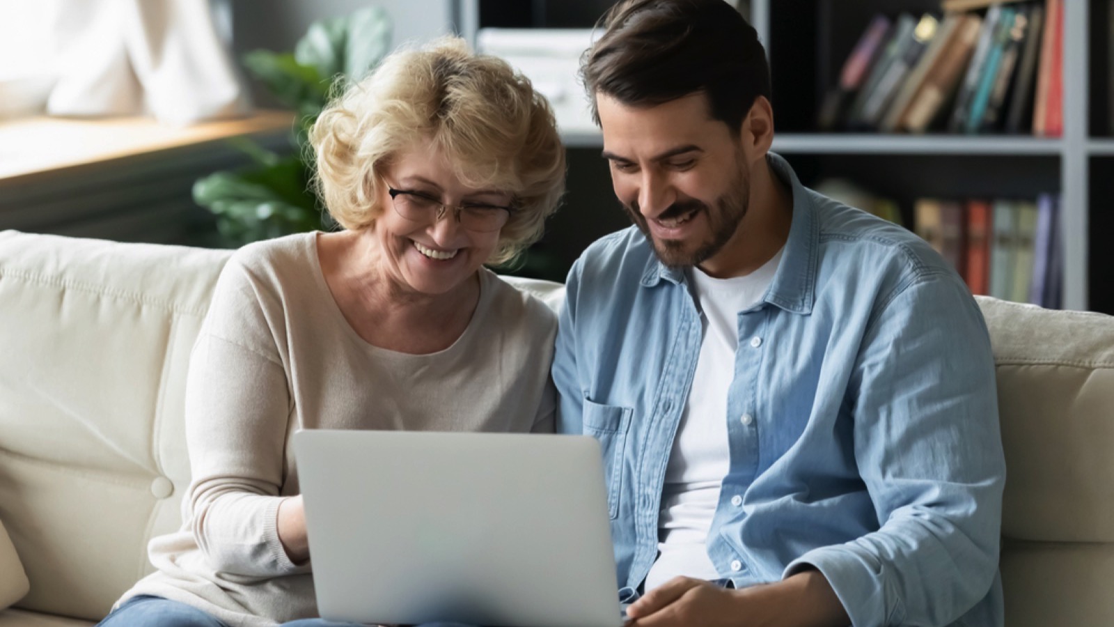 Man teaching mother about laptop