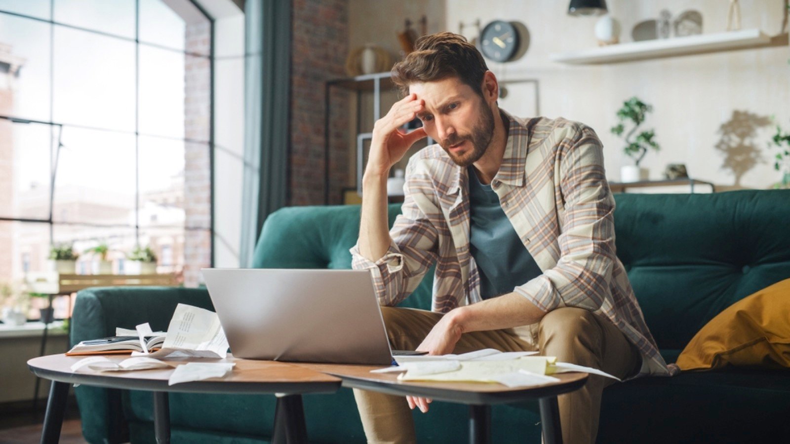 Man with laptop thinking about payments