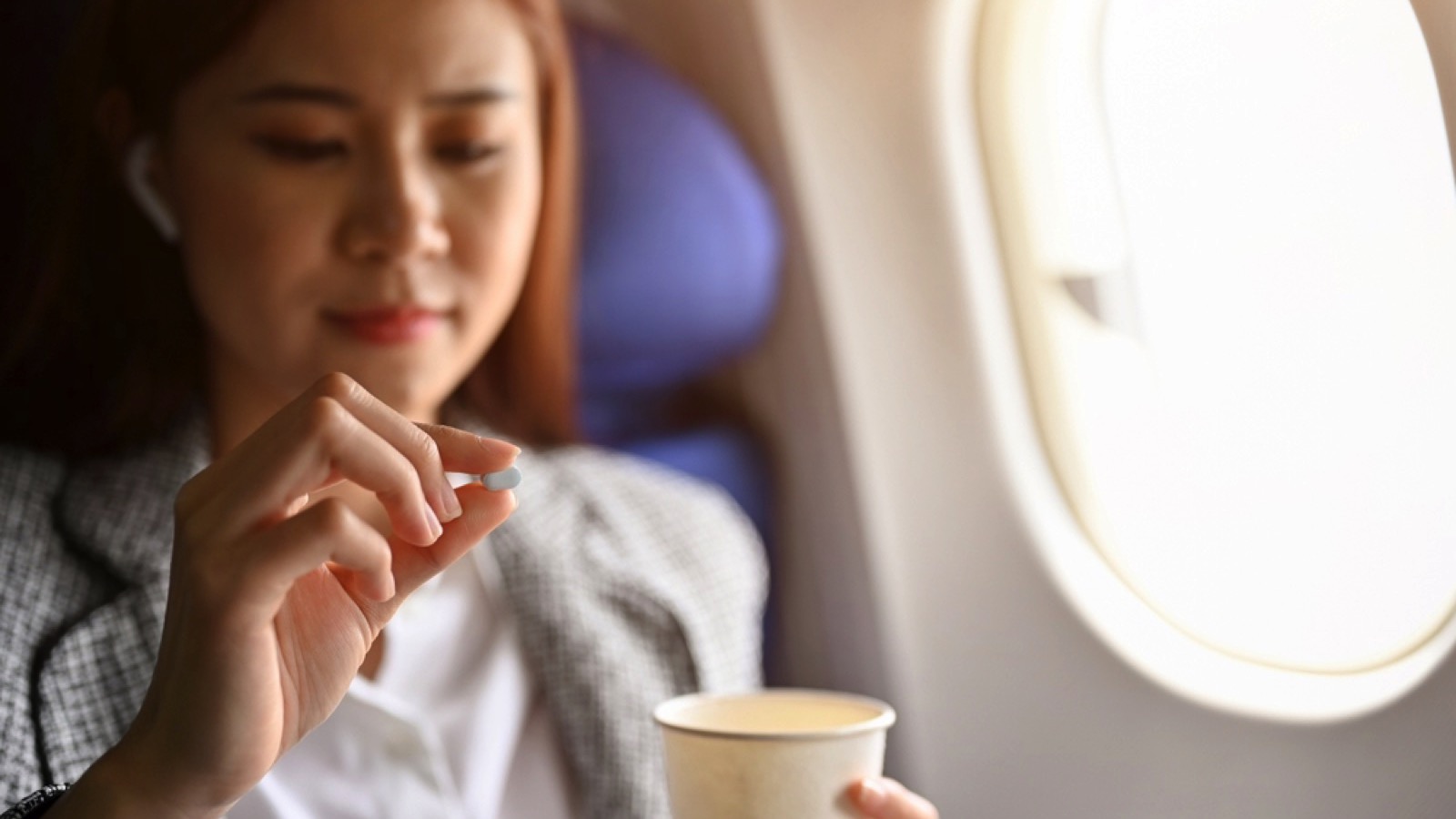 Woman taking medicine in flight