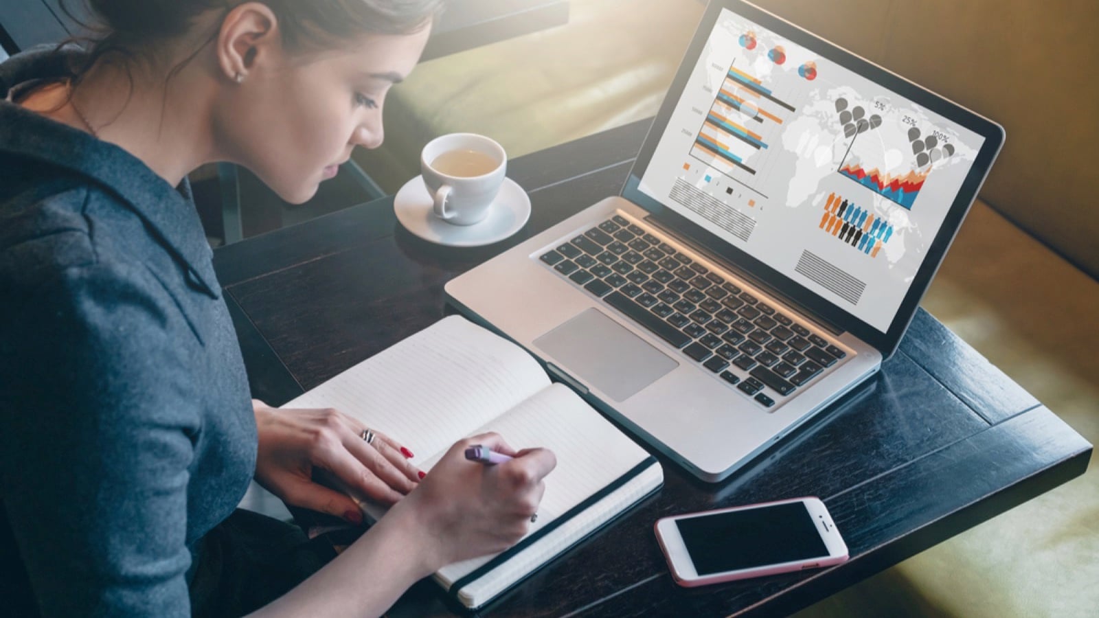 Woman with mobile taking notes