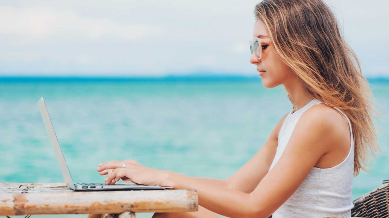 Young woman working near beach