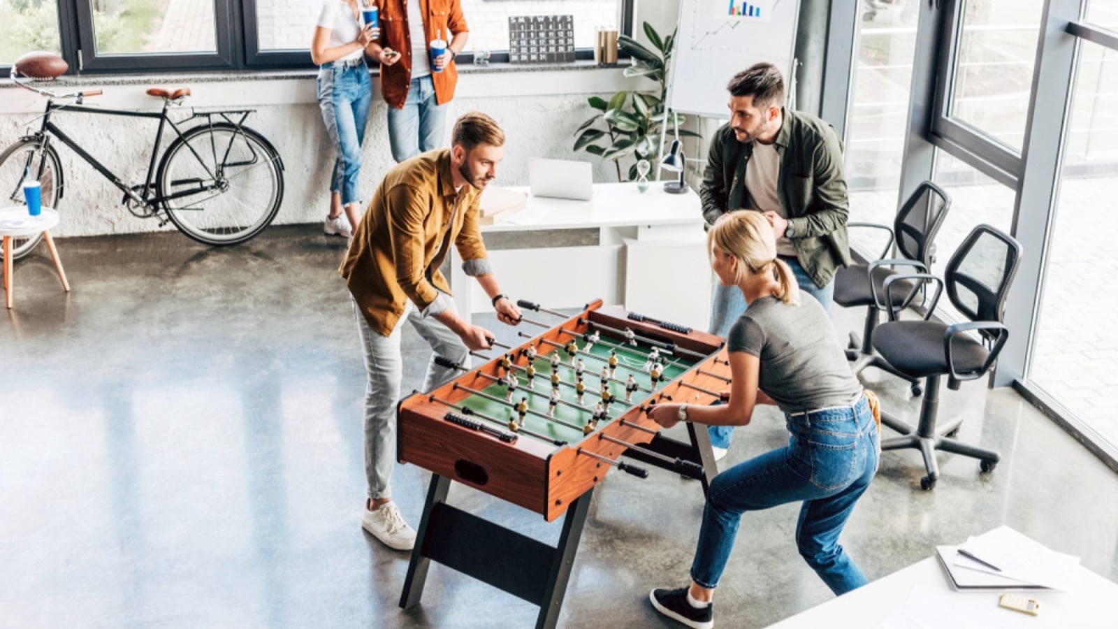 Business people playing table football