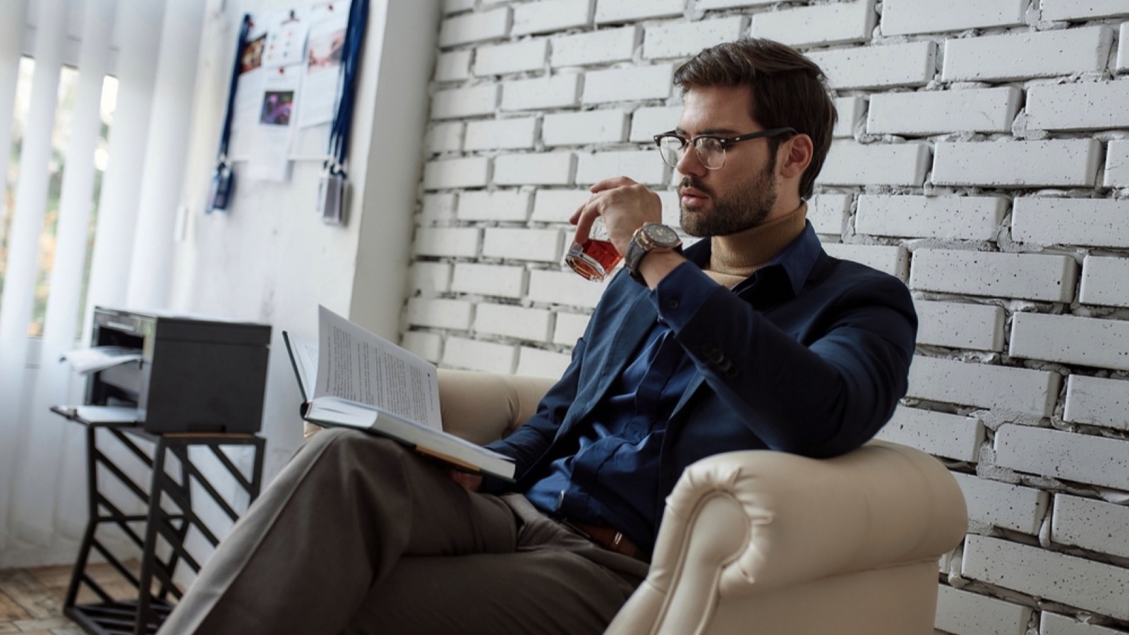 Businessma reading book having tea