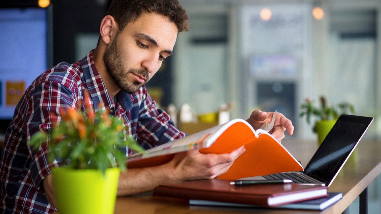 Handsome man in cafe reading book
