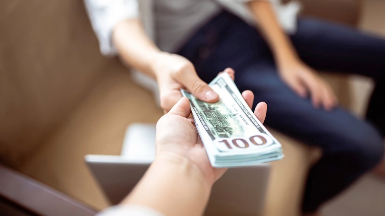 Man giving. bundle of money to family