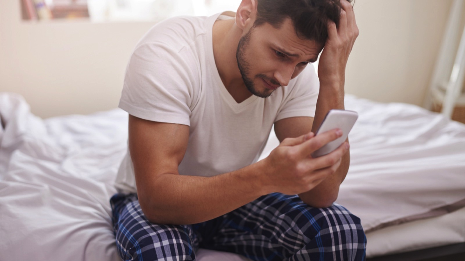 Man with mobile in hand thinking