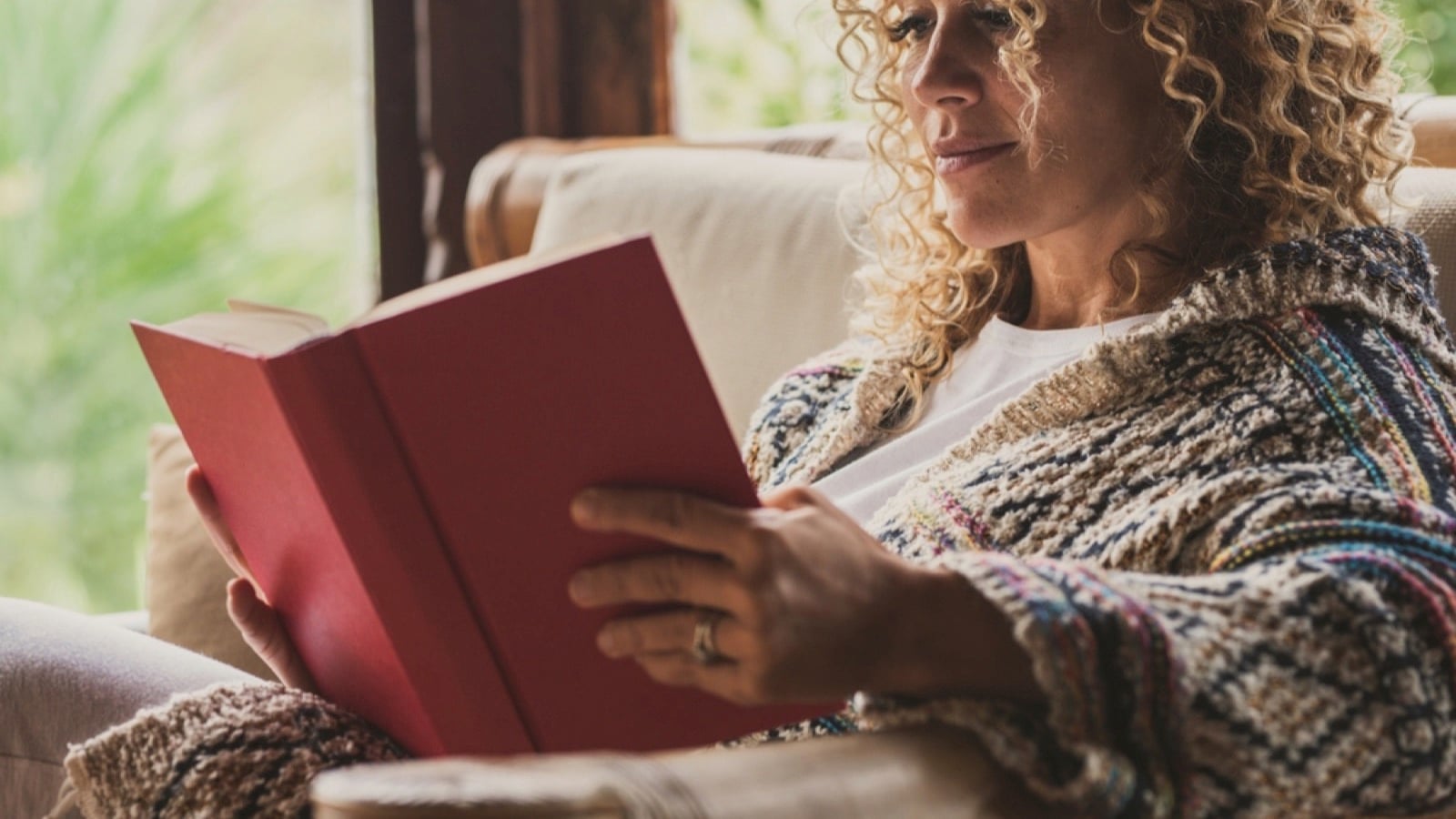 Woman on sofa reading book