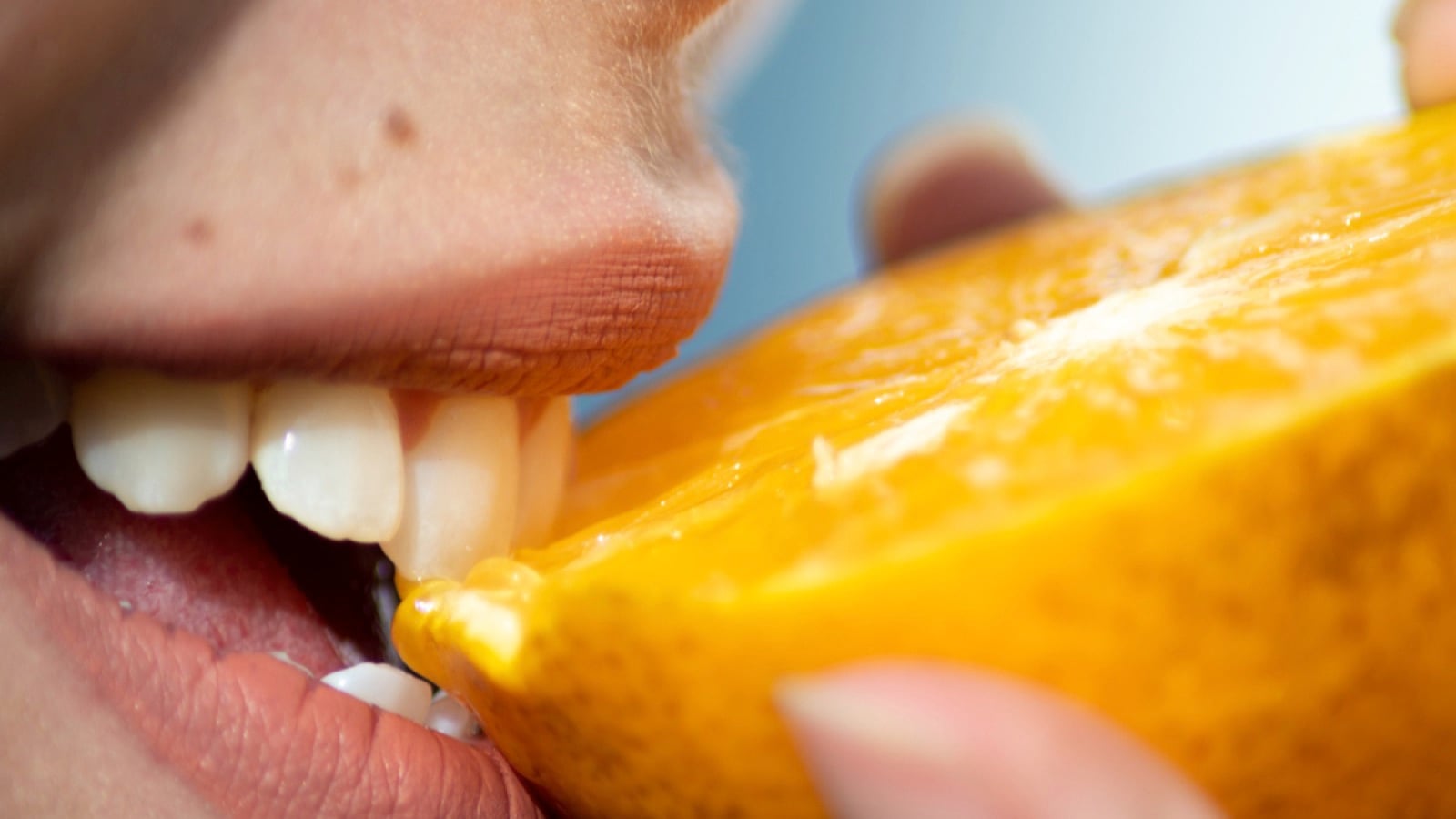 Woman eating orange with skin