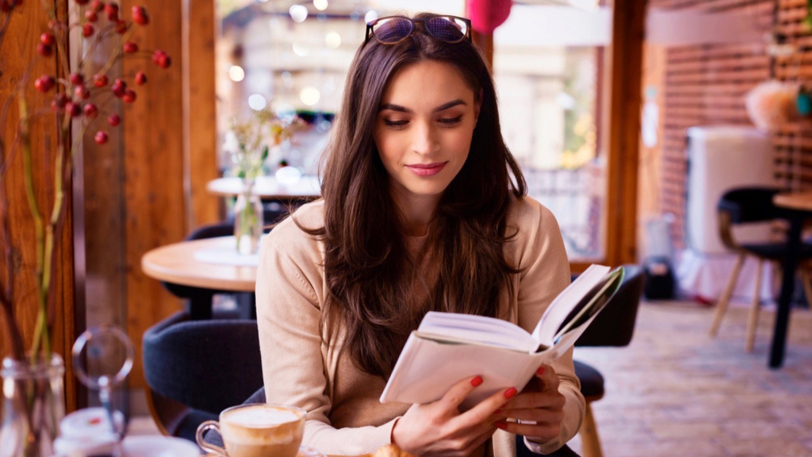 Woman in coffee shop reading book