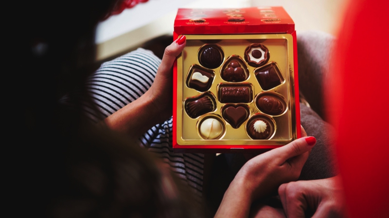 Woman opening box of chocolates