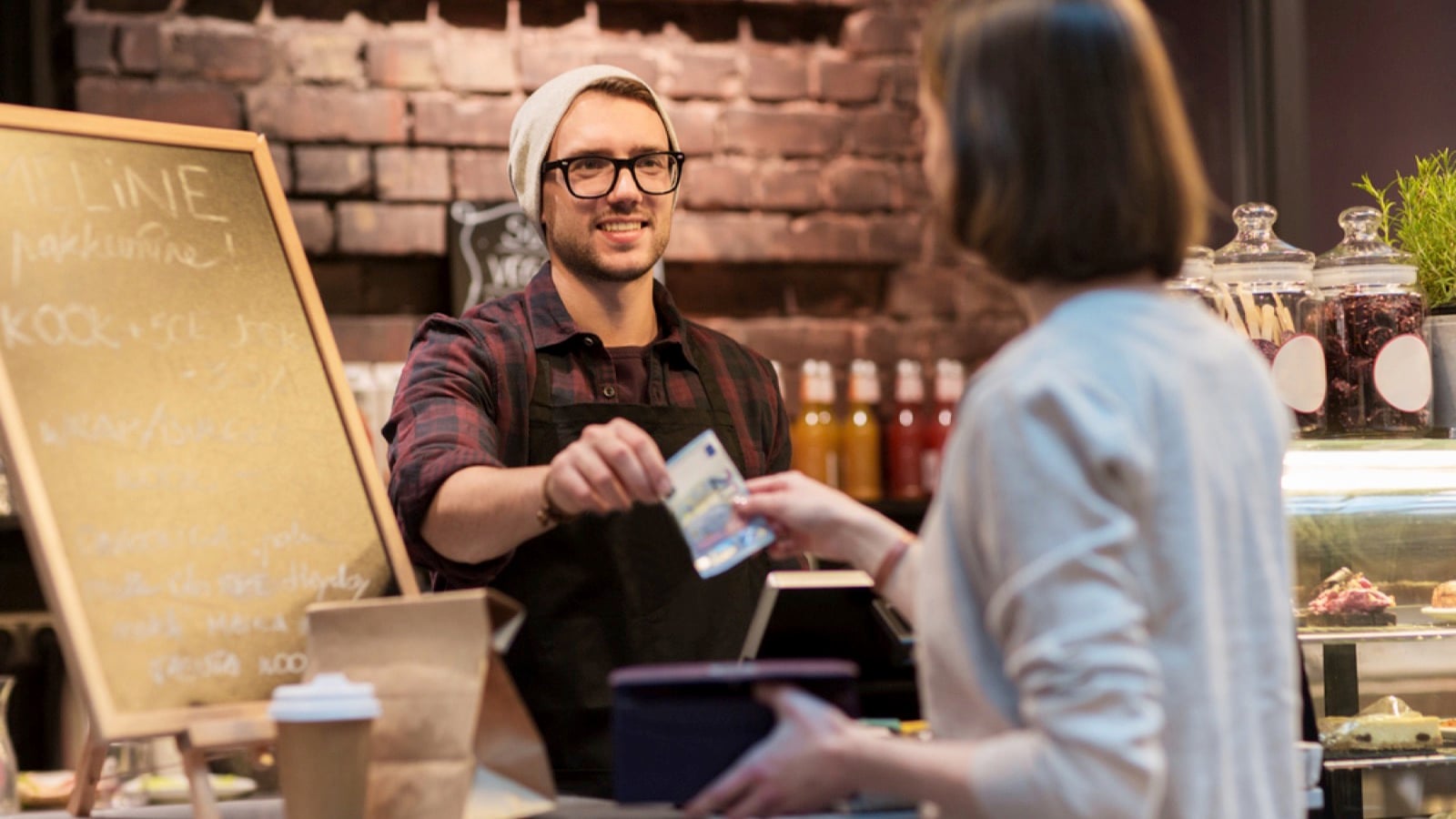 Woman paying in cash for barman