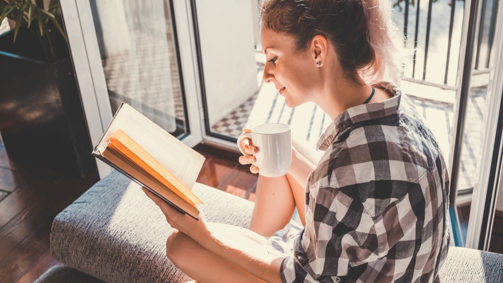 Woman with coffee reading book