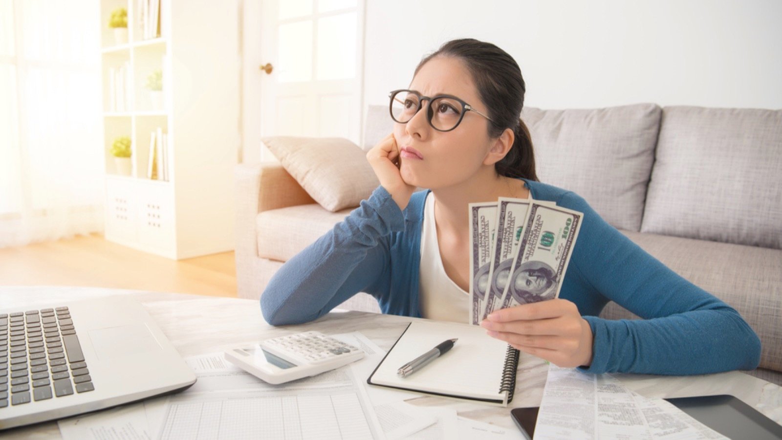 Woman with money thinking