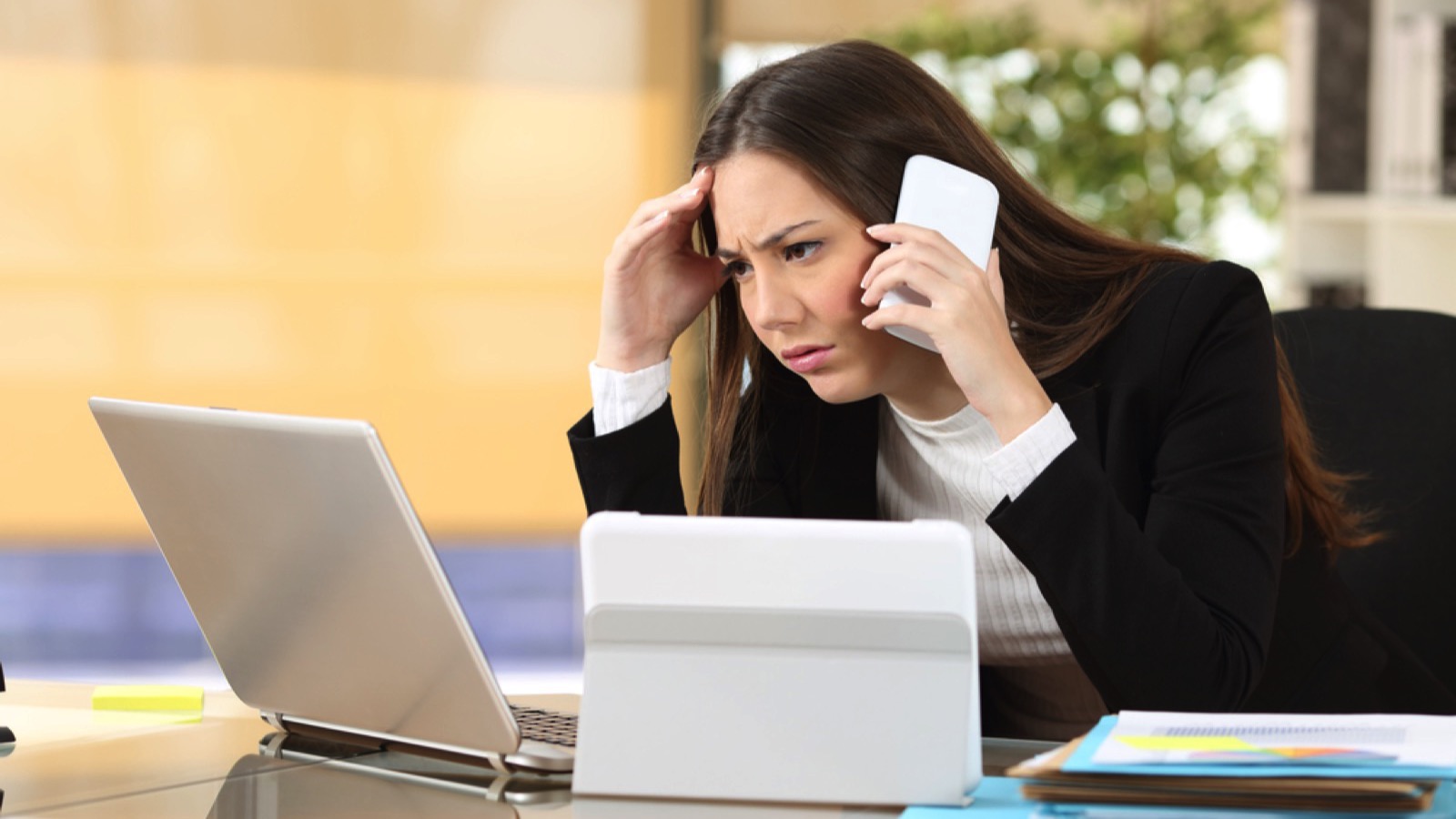 Woman working in different devices stressed in office
