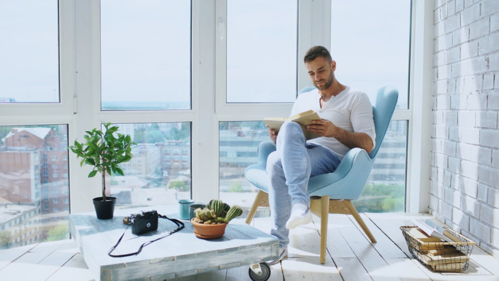 Young man reading book near balcony
