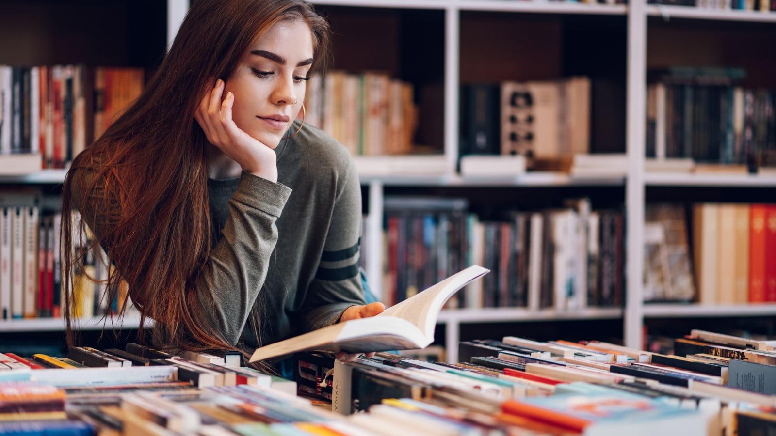 Young,Female,Customer,Reading,A,Book,In,Bookstore,While,Buying, thrift store