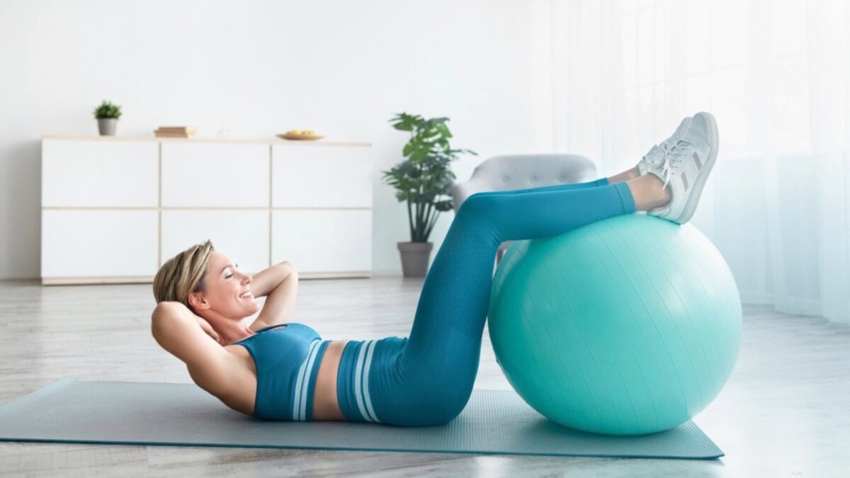 Woman doing exercise at home with exercise ball
