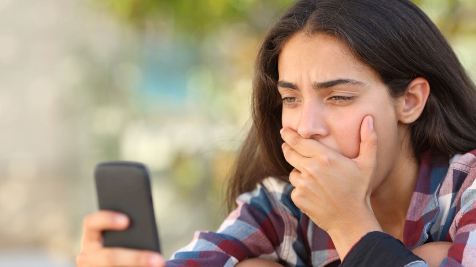 Teen girl using mobile depressed