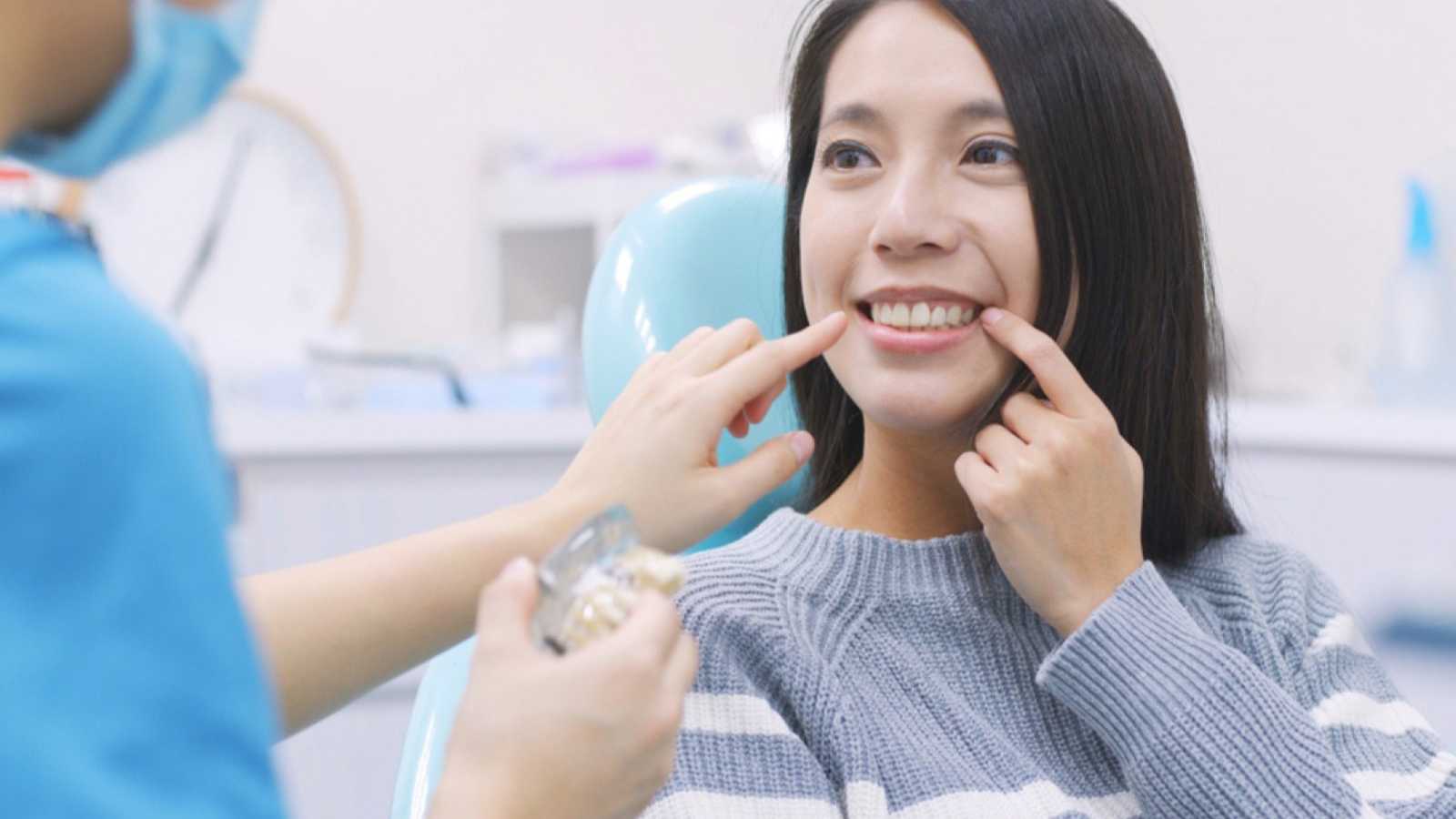Woman showing her teeth to doctor