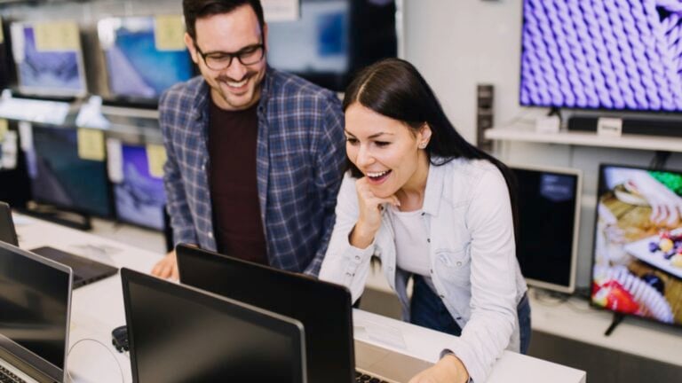 Couples buying laptop in shop