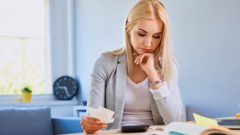 Sad young woman counting bills
