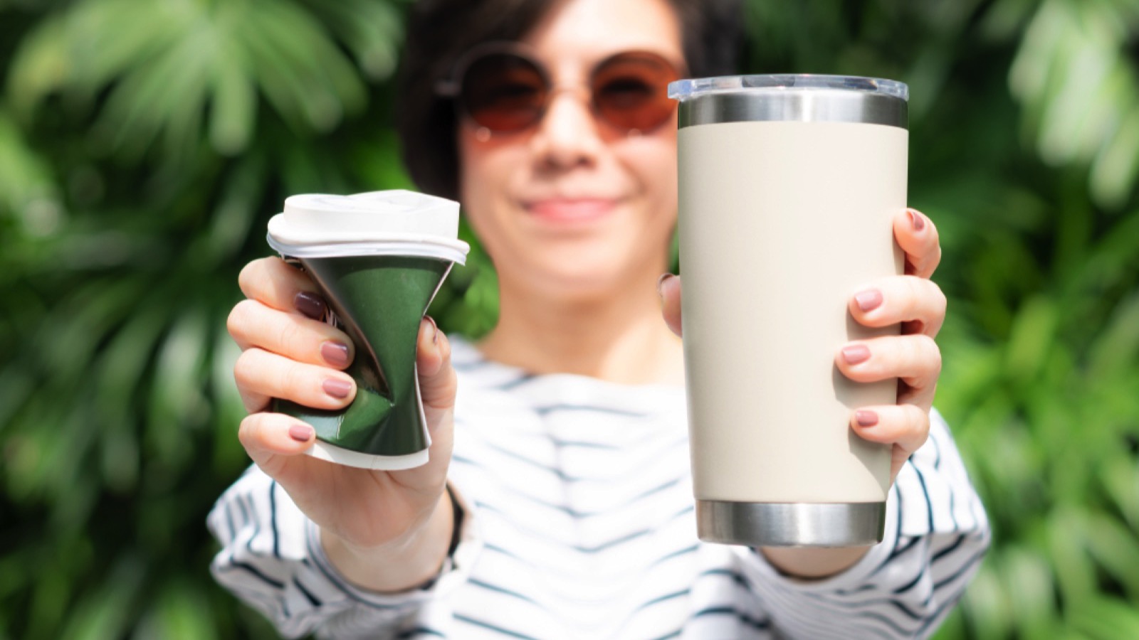 Woman holding reusable stainless tumblr