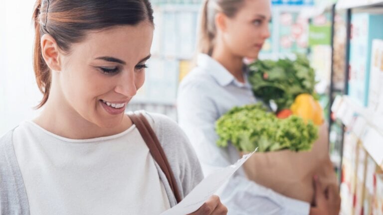 Woman shopping in supermarket with list