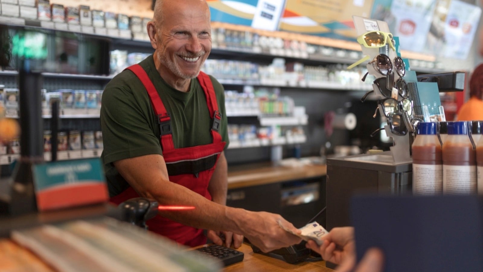 Employee taking cash in gas station-Paying With Cash