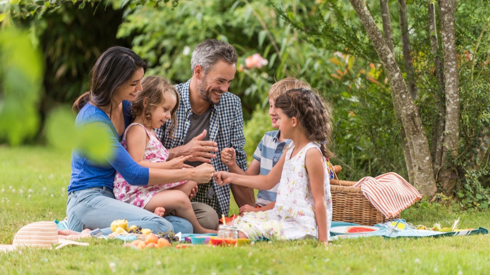 Family siting in park and having lunch
