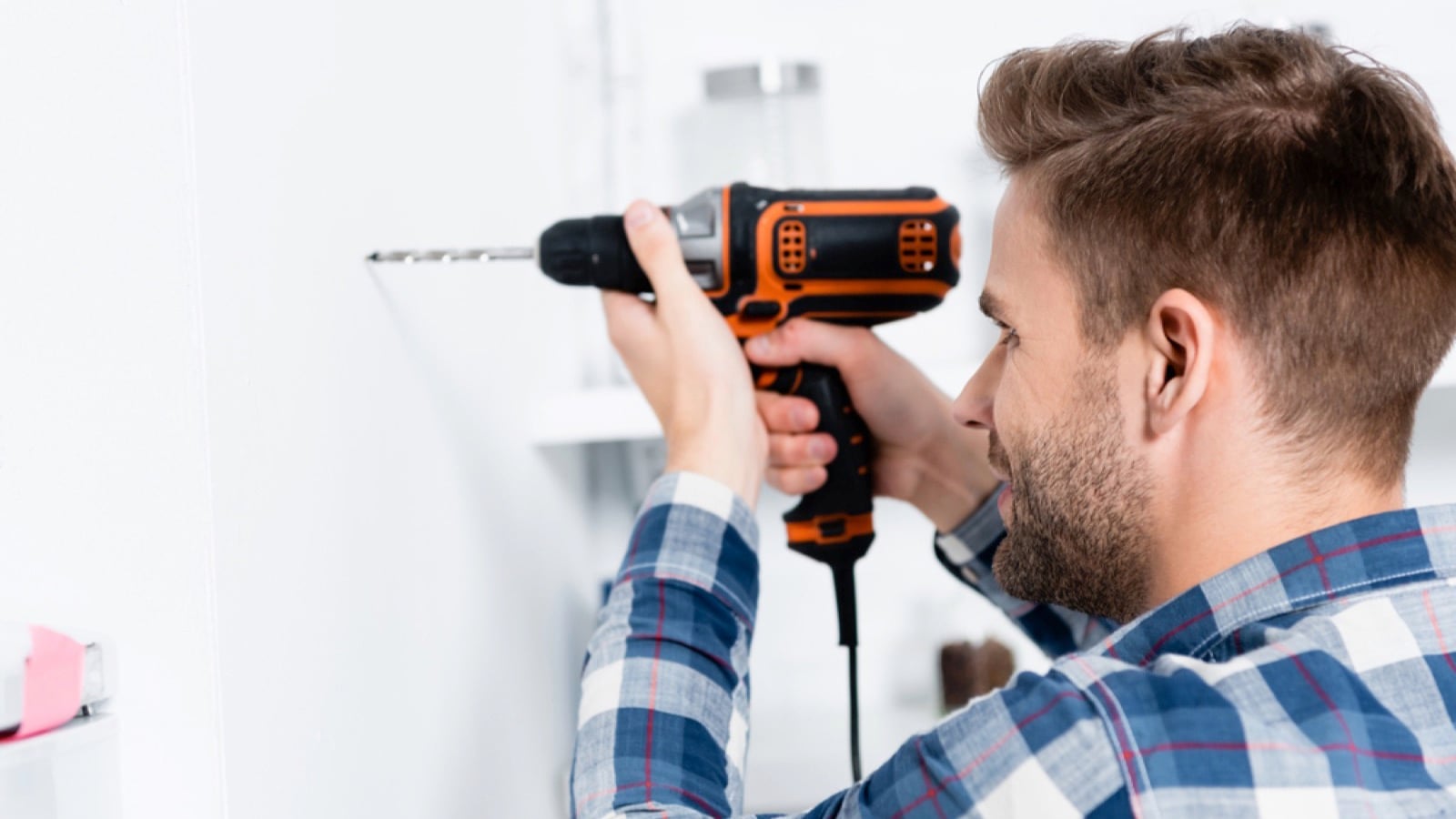 Man drilling kitchen wall