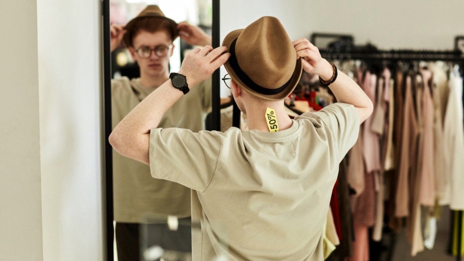 Man trying hat in thrift store