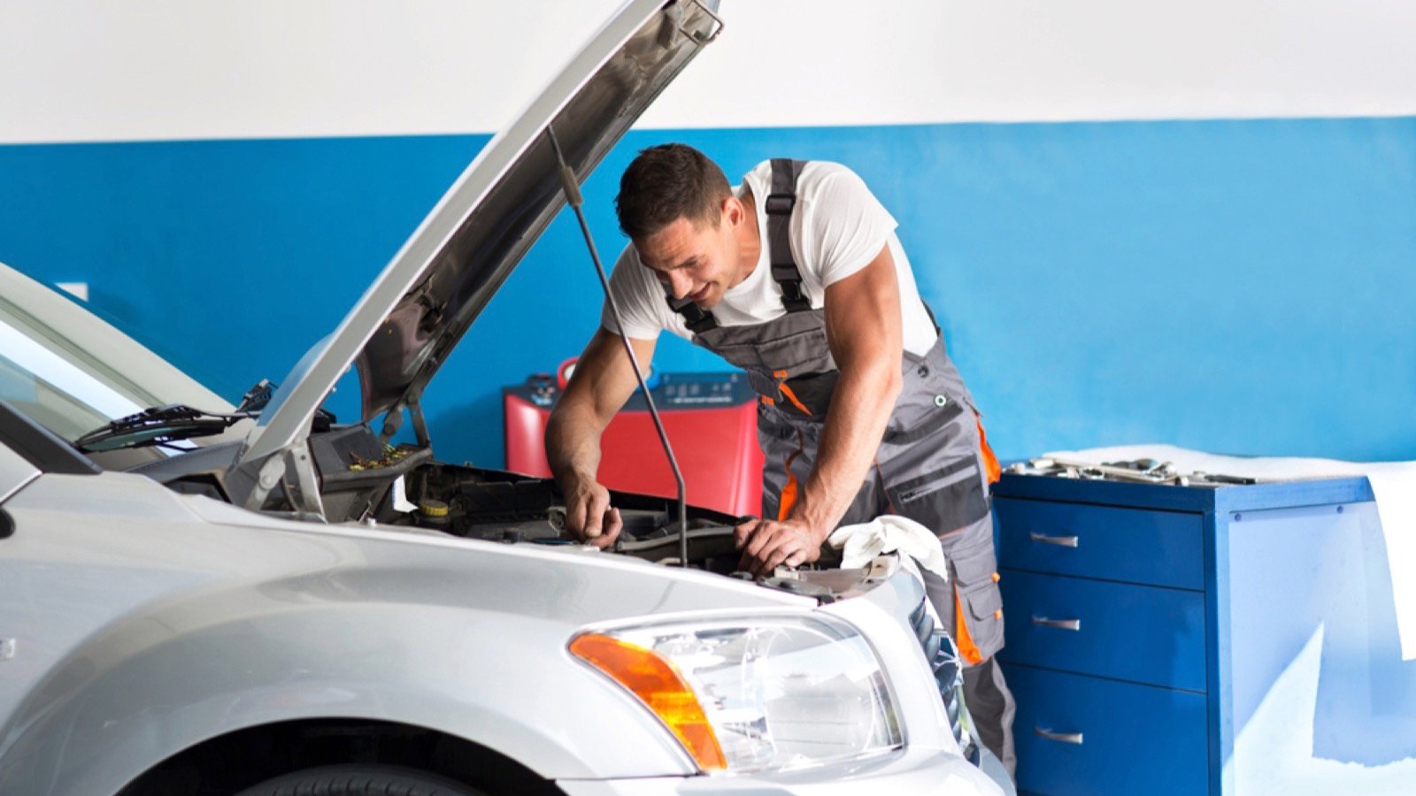 Mechanic repairing a lifted car, engine, service.