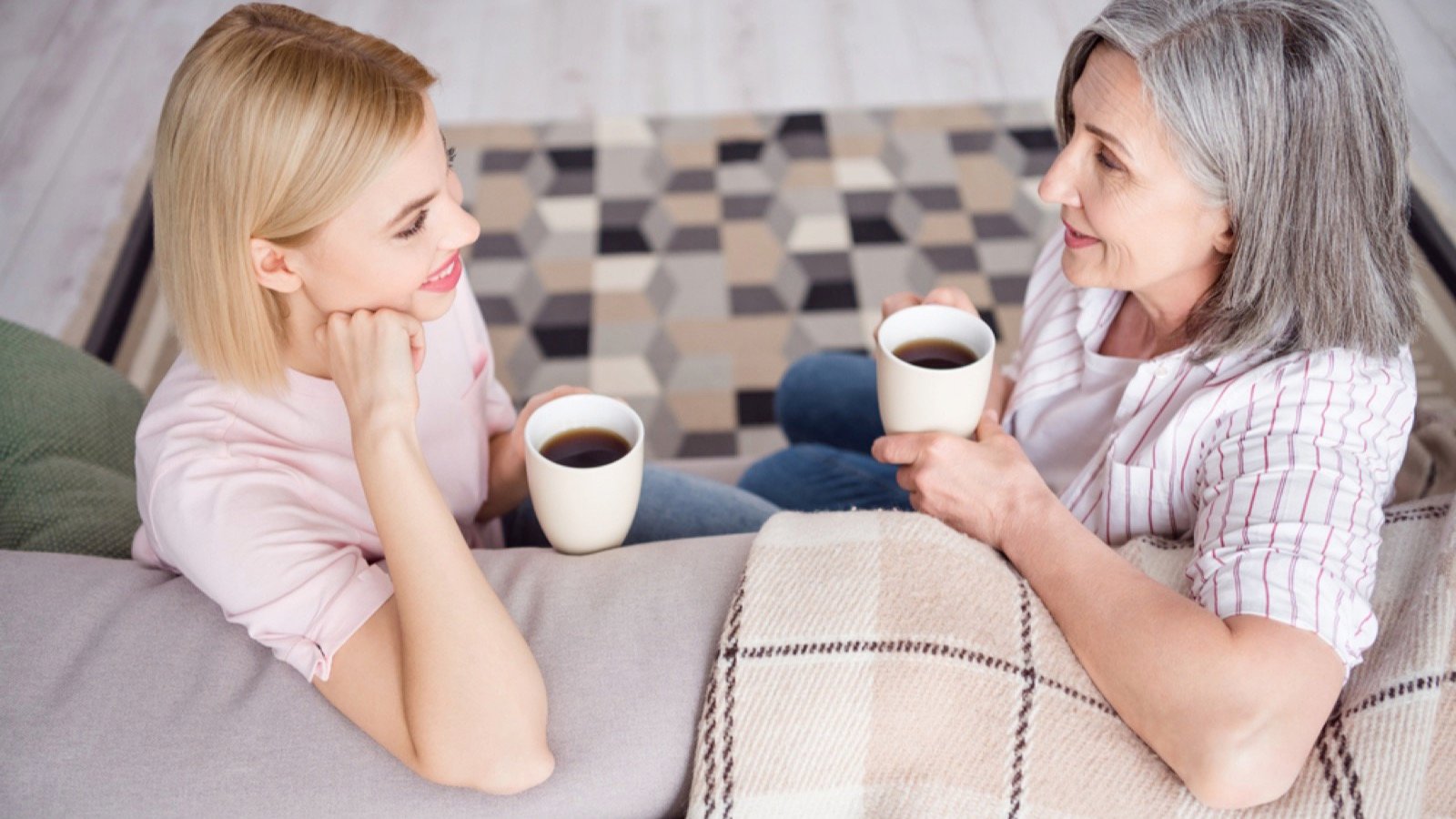 Mother and daughter having coffee and talking