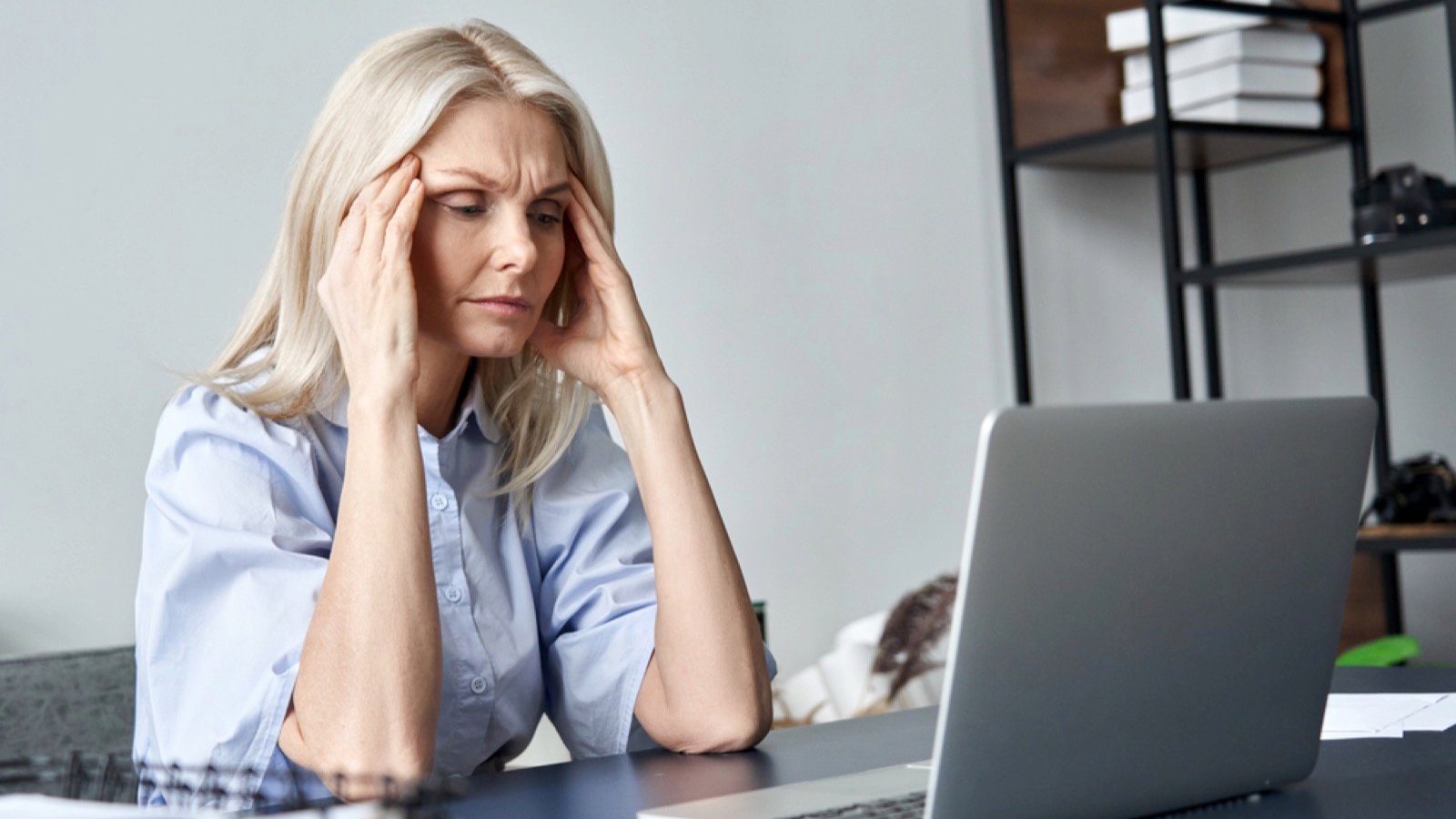Stressed old woman working in office