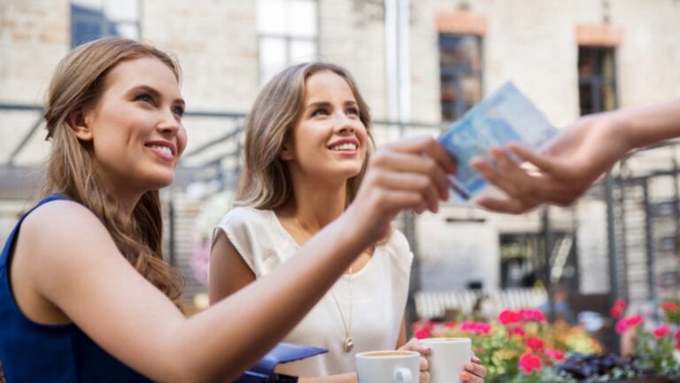 Women in cafe paying bill in cash
