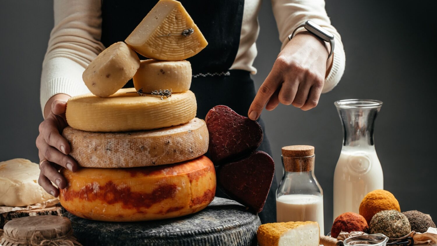 Woman holding wheels of artisan cheese