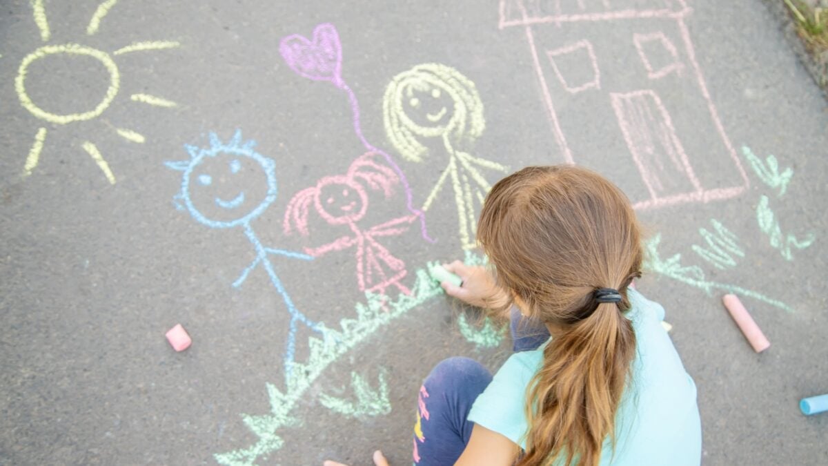 Little girl chalk drawing on the pavement / sidewalk