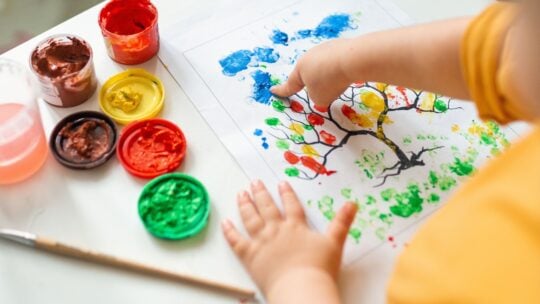 Child drawing a picture with finger paint
