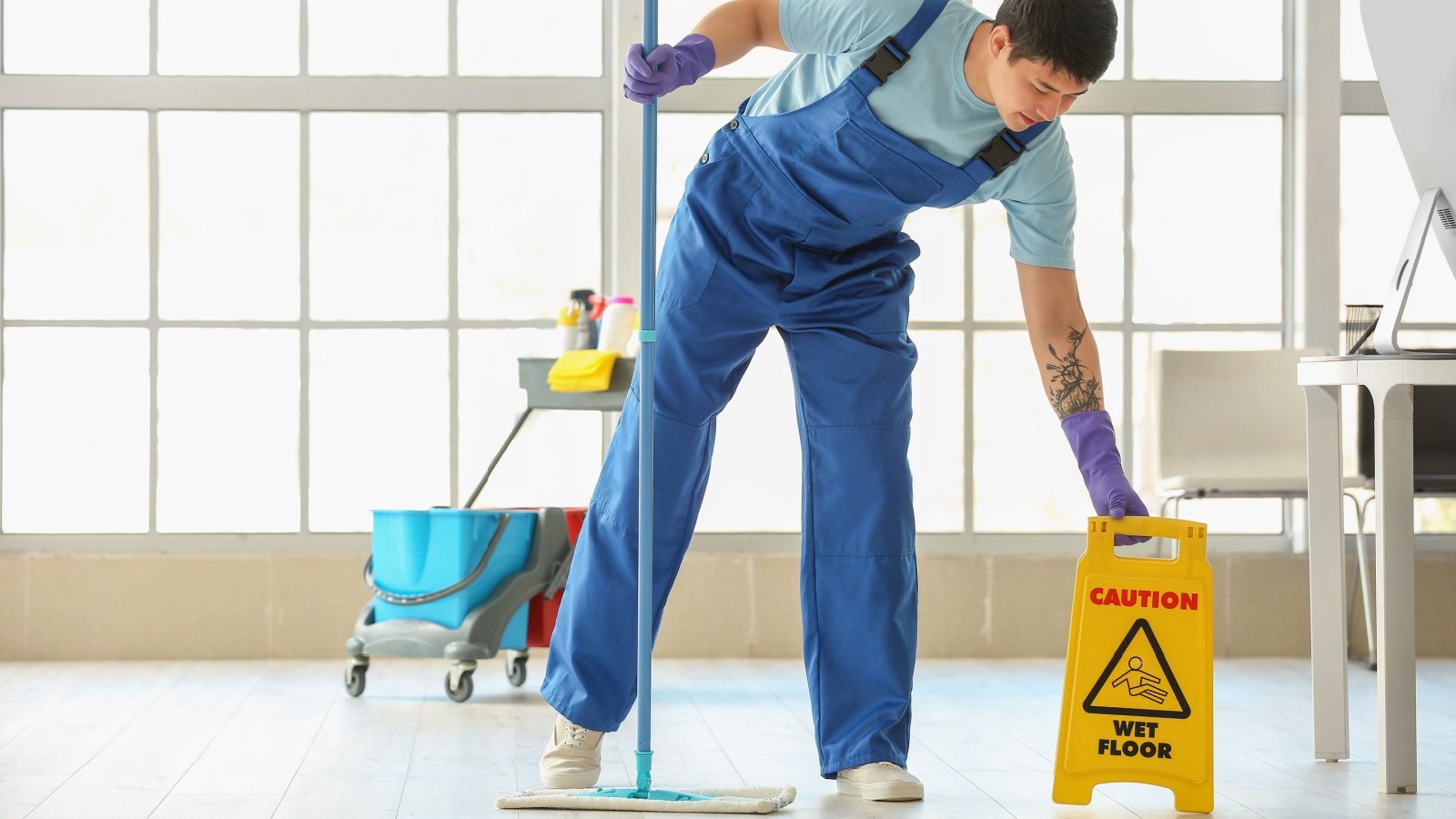 Male Janitor mopping the floor in an office