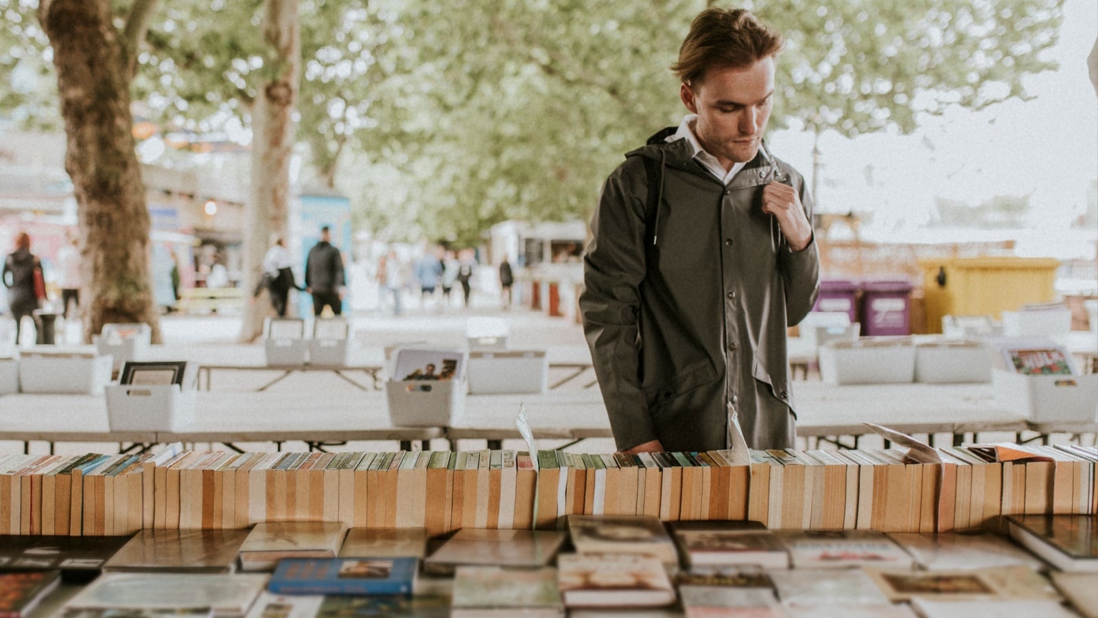 Young man browsing second hand books on a market stall