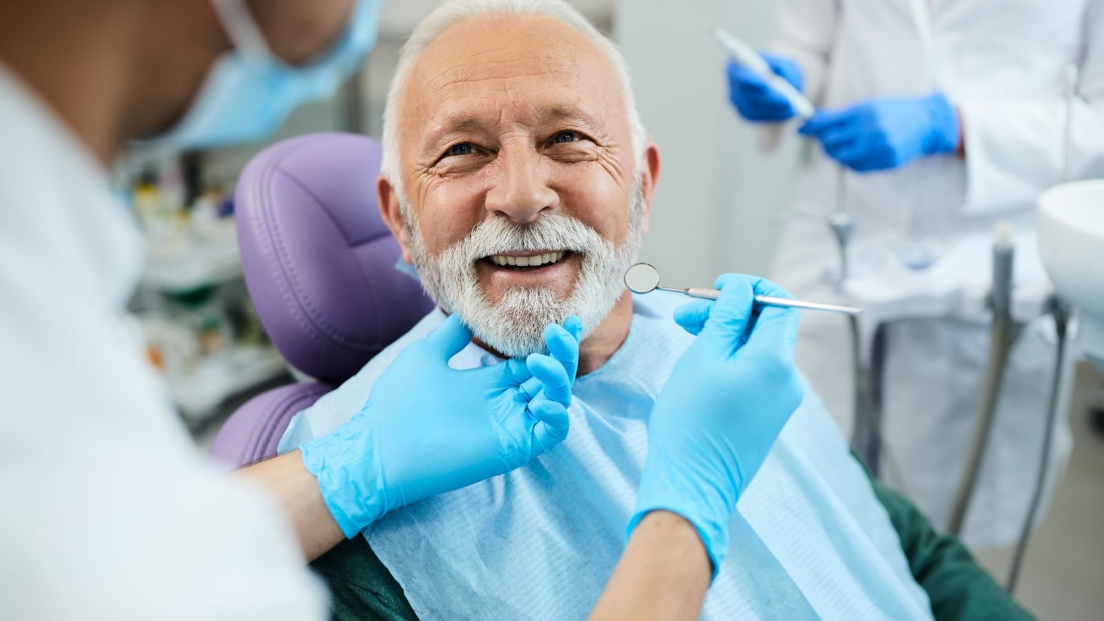 Happy senior man being examined by the dentist