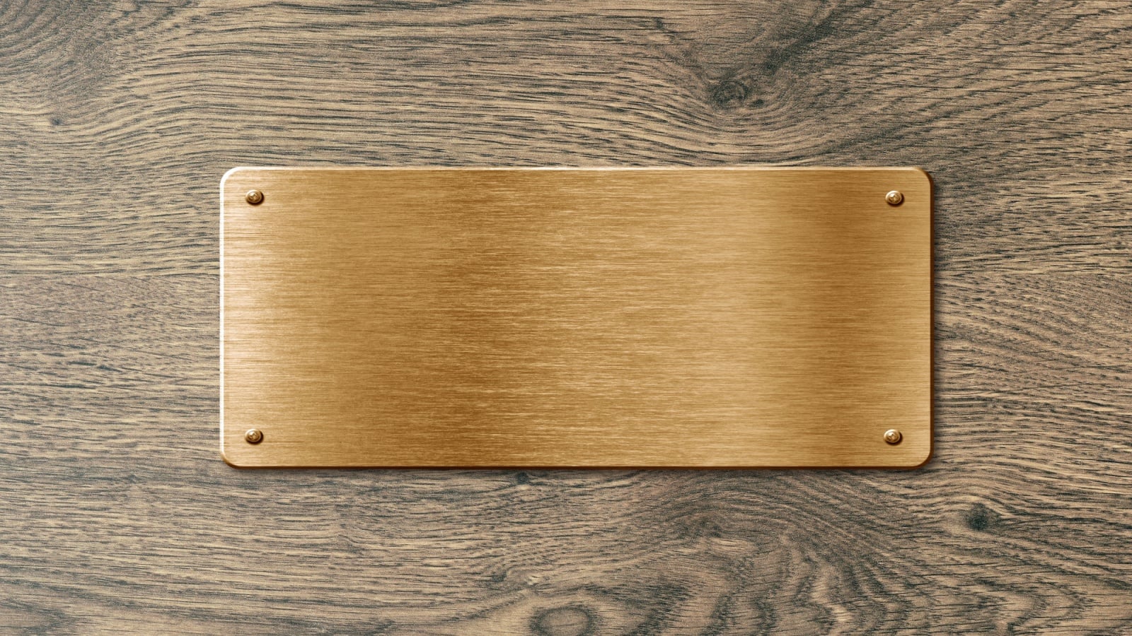 Blank polished golden colored name plate on wooden background to ad text.