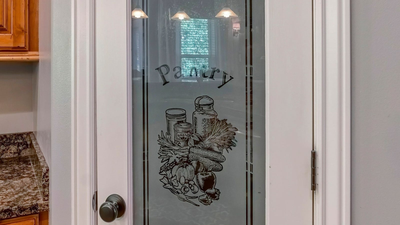 Pantry door with ornate glass panel with pantry signage.
