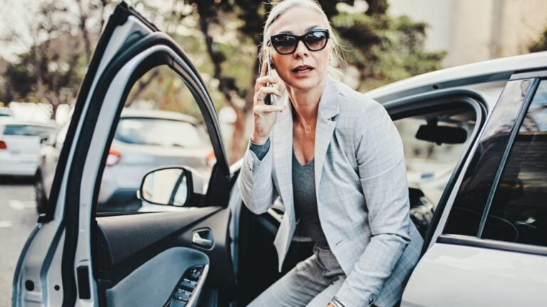 Senior Businesswoman Exiting Car