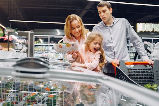 Inflation Happy family spending time together shopping at a grocery store.